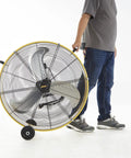 Person moving Heavy Duty High Velocity Barrel Floor Drum Fan With One Third HP Motor 13000 CFM 9 Foot Cord Five Inch Solid Wheels UL listed