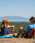 Two campers sitting on HEX 2.0 No Frills Outdoor Chair For Camping And Stadium Seating With All Terrain Comfort Adjustable Straps