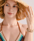 Premium Gold Boho Leather Wrap Bracelet Featuring Chunky Crystal Beads And Sparkling Rhinestone Layers With Strong Magnetic Clasp worn by a woman with a sun hat.