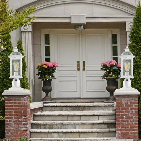 Entryway with white doors, flanked by Dusk To Dawn Outdoor Post Light With Seeded Glass for Patio Garden and Pathway on brick pillars.