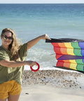 Person holding Rainbow Stripes 5.0 Parafoil Kite For All Ages - Frameless Single-Line Travel Kite on beach, visible rainbow pattern