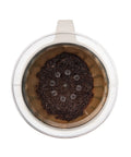 Top view of Single Serve Pour Over Coffee Maker With Auto Drip Tank For A Balanced Brew, showing unbleached filter with coffee grounds.