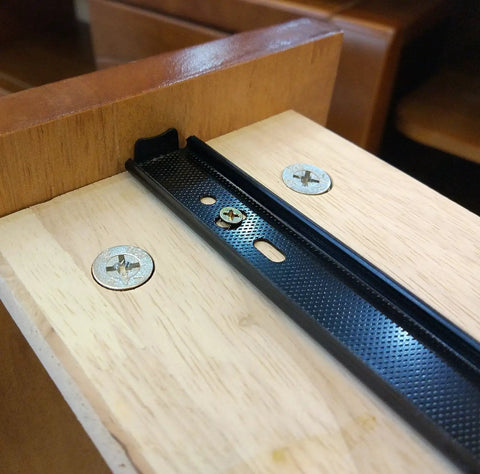 Close-up of black steel drawer glide, showing mounting on wooden drawer with screws, part of 12 Inch Full Extension Drawer Slides With Ball Bearing Rails, 3 Section Black Drawer Glide Pair For Cabinets And Furniture, Smooth Quiet Operation, Heavy Duty Steel Construction, Easy Mounting And Stable Mounting Holes.
