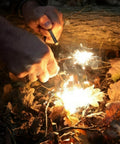 Using 4 Pack Five Sixteenth Inch Ferro Rod Fire Starters With Wood Handles And Multi Tool Striker to ignite leaves outdoors.