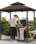 Man grilling under Patio Grill Gazebo Canopy With Double Tier Roof For Outdoor BBQ And Backyard Use Sturdy Powder Coated Steel Frame