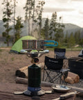 Portable Propane Stove With 10,000 BTU Burner chrome anti-clog design in campsite setting with pots and tents, ideal for outdoor use