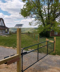 Solar Gate Opener Kit For Driveway Swing Gates Up To 20 Feet And 900 Pounds installed on wire mesh gate in countryside setting