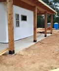 Laredo Sunset 8x8 Post Base Kit for Pergolas and Decks with galvanized steel construction securing wooden posts on a patio.