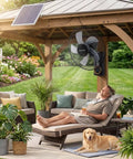 Man relaxing under gazebo cooled by 16 Inch Outdoor Solar Powered Wall Mount Fan For Patio And Garage, dog lying nearby