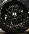 22X12 Satin Black Truck Wheels With 6X135 Bolt Pattern And Minus Forty Four Offset Aggressive Off Road Rims close-up view.