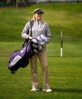 Woman holding M5 Women’s Golf Clubs Set For Right Hand Players With Titanium 460cc Driver, purple stand bag on course