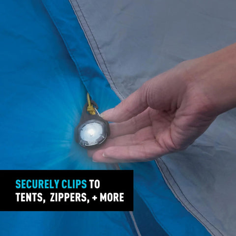 Close-up of Moonlit Rechargeable Micro Lantern for Camping and Hiking clipped to blue tent with carabiner