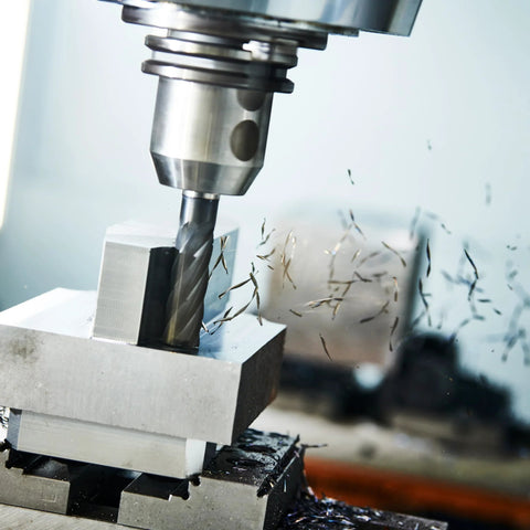 Carbide square end mill, 1/16 in, 4-flute, installed in milling spindle cutting metal with chips.