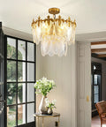 Next Level Two Layer Gold Crystal Glass Chandelier And Four Light Round Pendant Fixtures With Brushed Brass Finish in modern room.