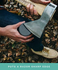 Person using Dual Grit Axe Sharpener Stone for Axe and Hatchet Large Whetstone Waterstone on axe blade outdoors.