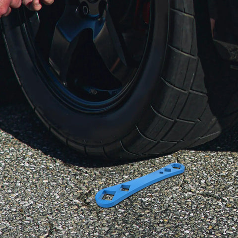 Heavy Duty Oil Drain Screw Removal Tool And 30mm Hexagonal Socket Wrench For Cars near a tire on asphalt surface.