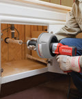 Professional Grade Pneumatic Air Powered 230V Drain Cleaning Tool in use under a sink for stubborn residential clogs.