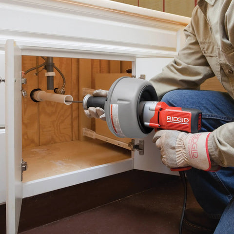 Professional Grade Pneumatic Air Powered 230V Drain Cleaning Tool in use under a sink for stubborn residential clogs.