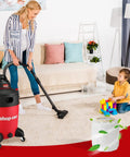 Woman vacuuming living room with wet dry vacuum, child playing, showcasing 2 Pack Dacron Cloth Filter Replacements For Most Wet Dry Vacuums 5 Gallon And Up, Durable Replacement Filters For Heavy Duty Cleanup And Dust Collection At Home In The Garage And Workshop.