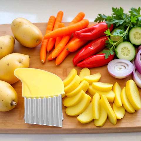 Front view of yellow crinkle cutter with stainless steel ridged blade on wooden board beside potatoes, carrots and peppers.