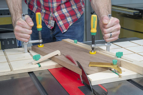 Person using Matchfit Dovetail Clamp Pro Router Bit Kit With One Half Inch Shank And Fourteen Degree Bit For Precision Dovetail Routing In Woodworking Track System Includes Clamps Setup Gauge Hardware Pack And Manual on wooden board.