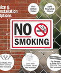No Smoking Sign 10 By 14 Inch Aluminum Sign With Screen Printed Symbol 40 Mil Laminated Rustproof Aluminum For Indoor Outdoor Use Made In USA Easy Mount With Corner Holes displayed against brick wall and chain-link fence with mounting options shown.