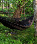 Person relaxing in Kompound Camping Hammock With Net And Warm Internal Cover Ultralight Portable Hammock With Tree Friendly Straps