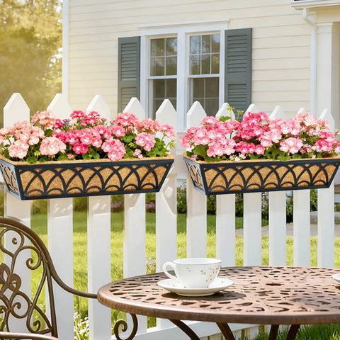 24 Inch Railing Planter Box Set With Adjustable Brackets And Coco Liners 2 Pack Balcony Deck Flower Boxes For Windows And Railings Weatherproof Metal Planters For Outdoor Garden Decor mounted on white picket fence with pink flowers.