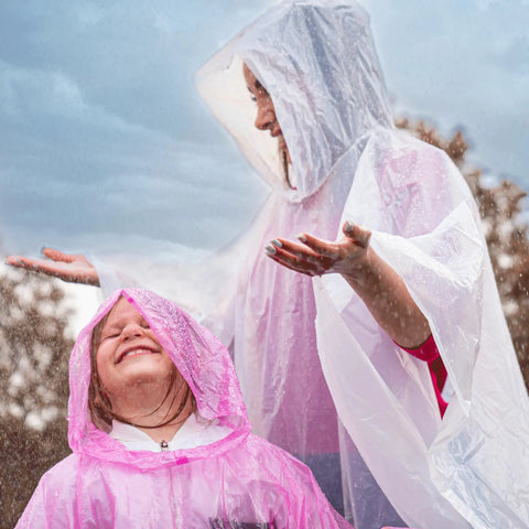 Adults wearing Four Pack Disposable Rain Ponchos With Hood For Adults Clear See Through Emergency Rain Gear Lightweight And Waterproof