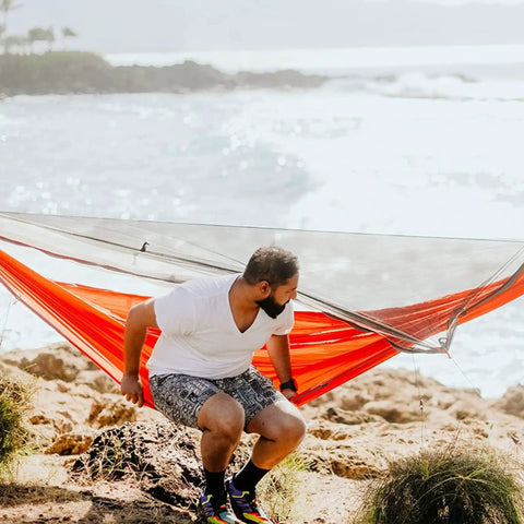 Man sitting on Mantis Ultralight Hammock With Mosquito Net And Storage Bag For All Seasons, Featherlight Levitas 20D Nylon Ripstop Fabric