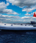 Inflatable boat with a Dive Flag With Removable Stiffening Pole 20x24 Inches For Scuba, Spearfishing, And Freediving on open sea