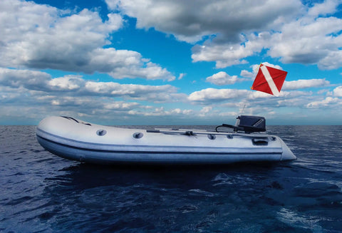 Inflatable boat with a Dive Flag With Removable Stiffening Pole 20x24 Inches For Scuba, Spearfishing, And Freediving on open sea