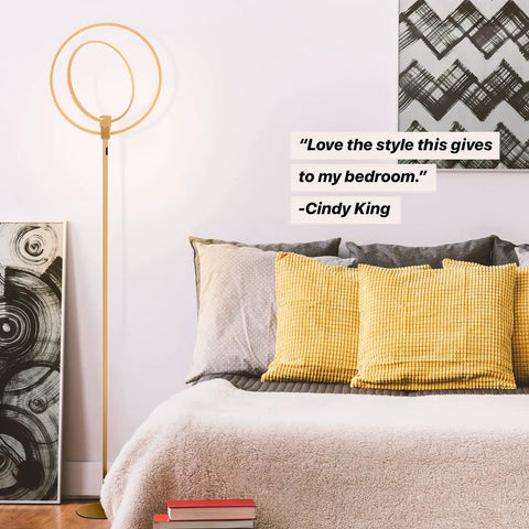 Eclipse Dope Bright Modern LED Torchiere Floor Lamp With Built In Touch Dimmer next to a bed with yellow pillows