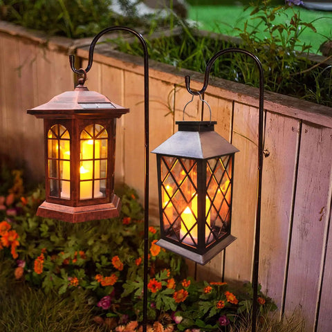 Flickering Lantern With 3 Flameless Candles, Waterproof PVC Garden Hanging Lights glowing in garden at night with plants.