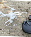 White drone with remote controller on dirt ground, image not related to 20 Sets Aircraft Control Horns and Connectors for Model Airplanes, Linkage Stopper Parts for Fixed-Wing Aircraft, Durable Metal, Easy Installation, Bulk Pack for RC Projects.