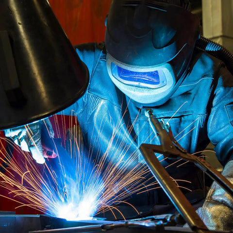 Close-up of welding process showcasing sparks and clear optics, using Top Shelf Hardened Glass Welding Filter Lens Plates 15 Pack 4 1/4 X 2 Inch Replacement Protection Lenses.