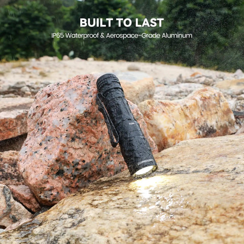 M70 EDC Flashlight 1100 Lumens USB C Rechargeable Pocket Light with Clip on wet rocks, durable for outdoor use.