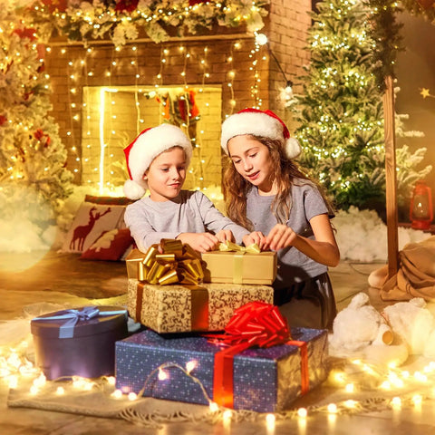 Children opening presents by a fireplace decorated with Battery Operated Globe Fairy String Lights With Remote, 21Ft Long, 60 Warm White LEDs, Waterproof Twinkle Lights For Indoor Outdoor Decor, Patio Bedroom Camping Christmas Party Lighting Totally Cozy
