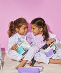 Two children painting with Barbie Dreamhouse Pink Cabinet And Door Paint With Semi Gloss Finish, smiling in paint-splattered clothes.