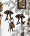 Straight Up Legit Mushroom Wall Hooks Set Of Two Heavy Duty Cast Iron Coat Hangers With Antique Black Finish, holding keys.