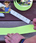 Hands applying Grippy Black Grip Tape For Stairs And Outdoor Use, Waterproof, Ultra Strong Adhesive, Clear Non Slip Stair Treads Tape, 4 Inch Wide By 30 Feet, Keeps Wet Walkways From Slipping with ruler on wooden steps