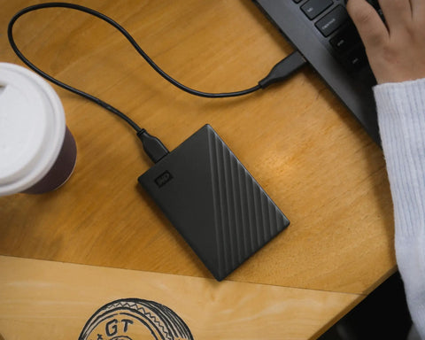 5TB Portable External Hard Drive with Ransomware Defense and Password Protection connected to laptop on wooden desk, USB 3.1/3.0 compatible.