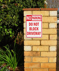 Heavy Duty No Parking And Do Not Block Driveway Sign 14X10 Inch Reflective Aluminum mounted on a brick post in a garden.