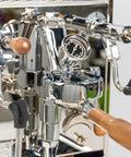 Pro Grade Dual Boiler Espresso Maker With PID Precision Tuning hardened stainless frame, detailed view showing portafilter and gauge.