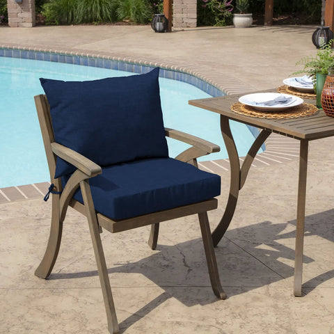 Outdoor Dining Chair Cushion Set 21 By 21 Inches In Sapphire Blue Rainproof And Fade Resistant Includes One Back Pillow And One Seat Bottom Eco Friendly PFAS Free C0 Treatment With Recycled Polyfill And Polyester Fill Fits Most Chairs on a wooden chair by a poolside table.