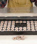 Hands assembling 72 Coconut Coir Seed Starter Pellets Kit With Humidity Dome And Watertight Tray 35mm Peat Free Pellets