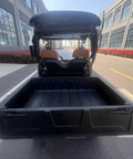 Yellow Electric Golf Cart Two Seater With Cargo Bed showing rear view and spacious cargo area on a sunny day.