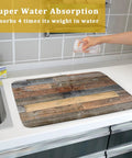 Pouring water on Wood Grain Dish Drying Mat For Kitchen Countertop 18x24 Inch Large Beast Absorbent Reversible Microfiber Pad With Waterproof Backing Rustic Barnwood Look Drainer Mat For Quick Drying And Easy Cleanup showing super absorption