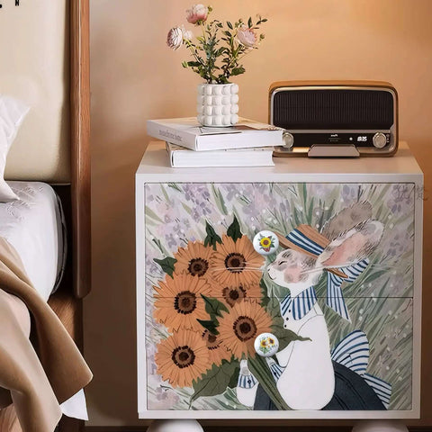 A nightstand featuring pretty sunflower and butterfly art, decorated with eight ceramic kitchen cabinet drawer knobs.