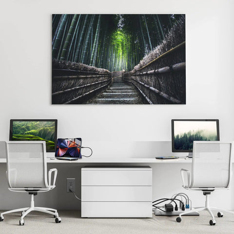 Modern home office setup with two desks and chairs, featuring tech gadgets and a large bamboo forest artwork on the wall.